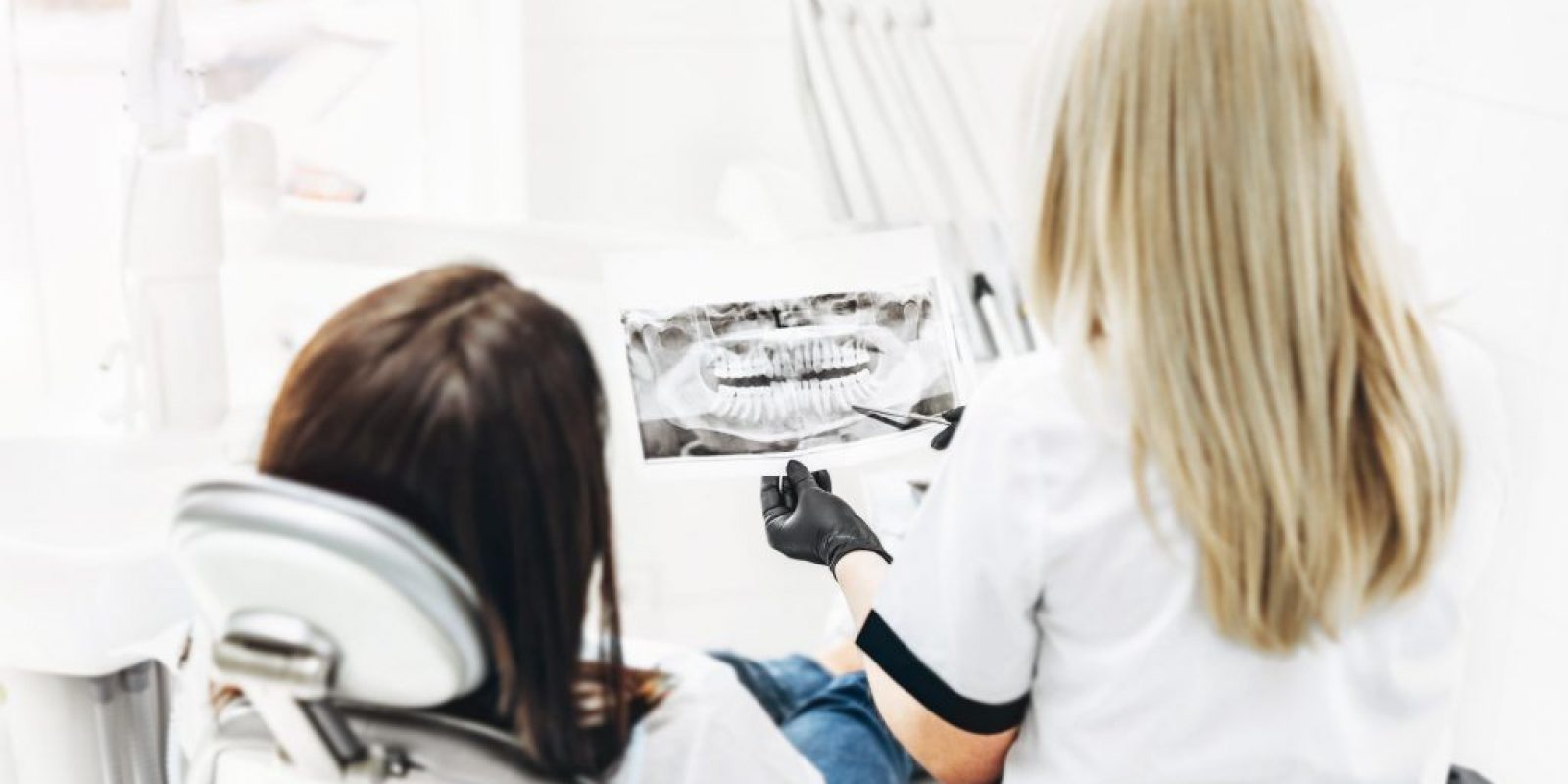Dentist showing x-ray for the patient and explaining plan of tre