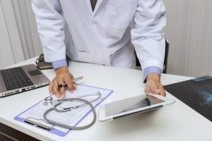 Doctor working with tablet computer at desk. Technology and medical concept.