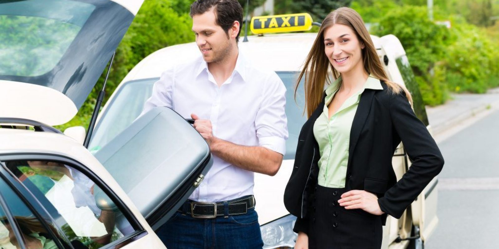 Young businesswoman in front of taxi with luggage