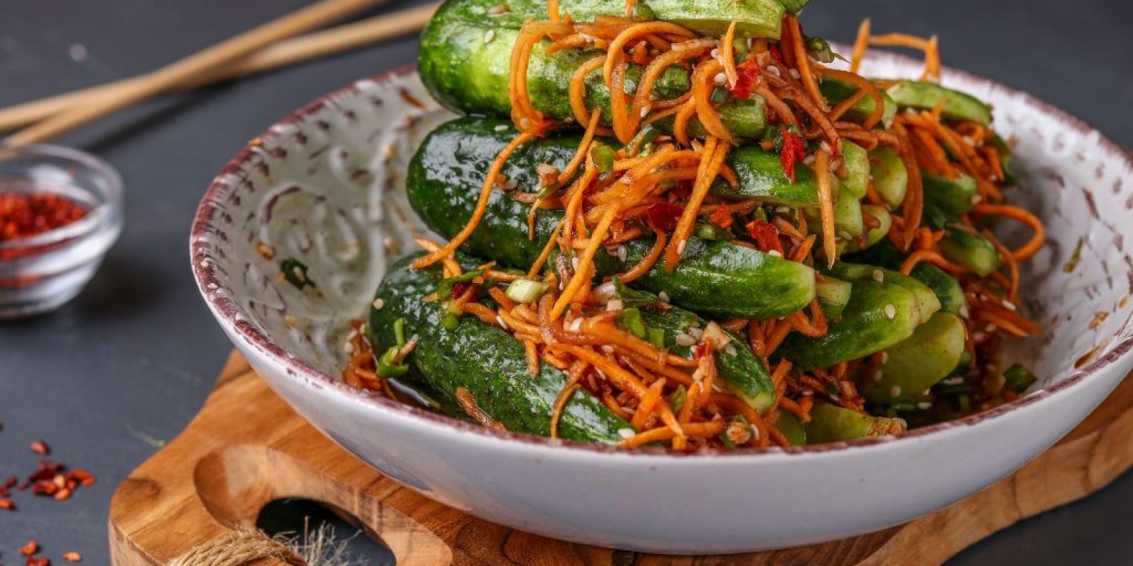 Traditional Korean cucumber kimchi snack: cucumbers stuffed with carrots, green onions, garlic and sesame, fermented vegetables, horizontal photo
