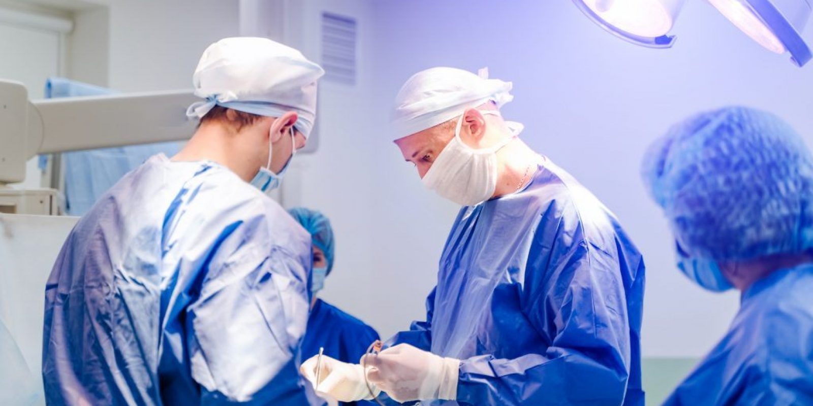 Process of surgery operation using medical equipment. Group of surgeons in operating room with surgery equipment. Medical background.