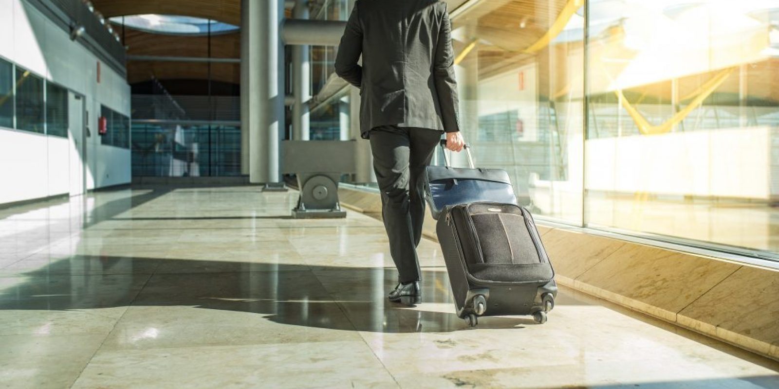 businessman back and lengs walking with luggage at the airport