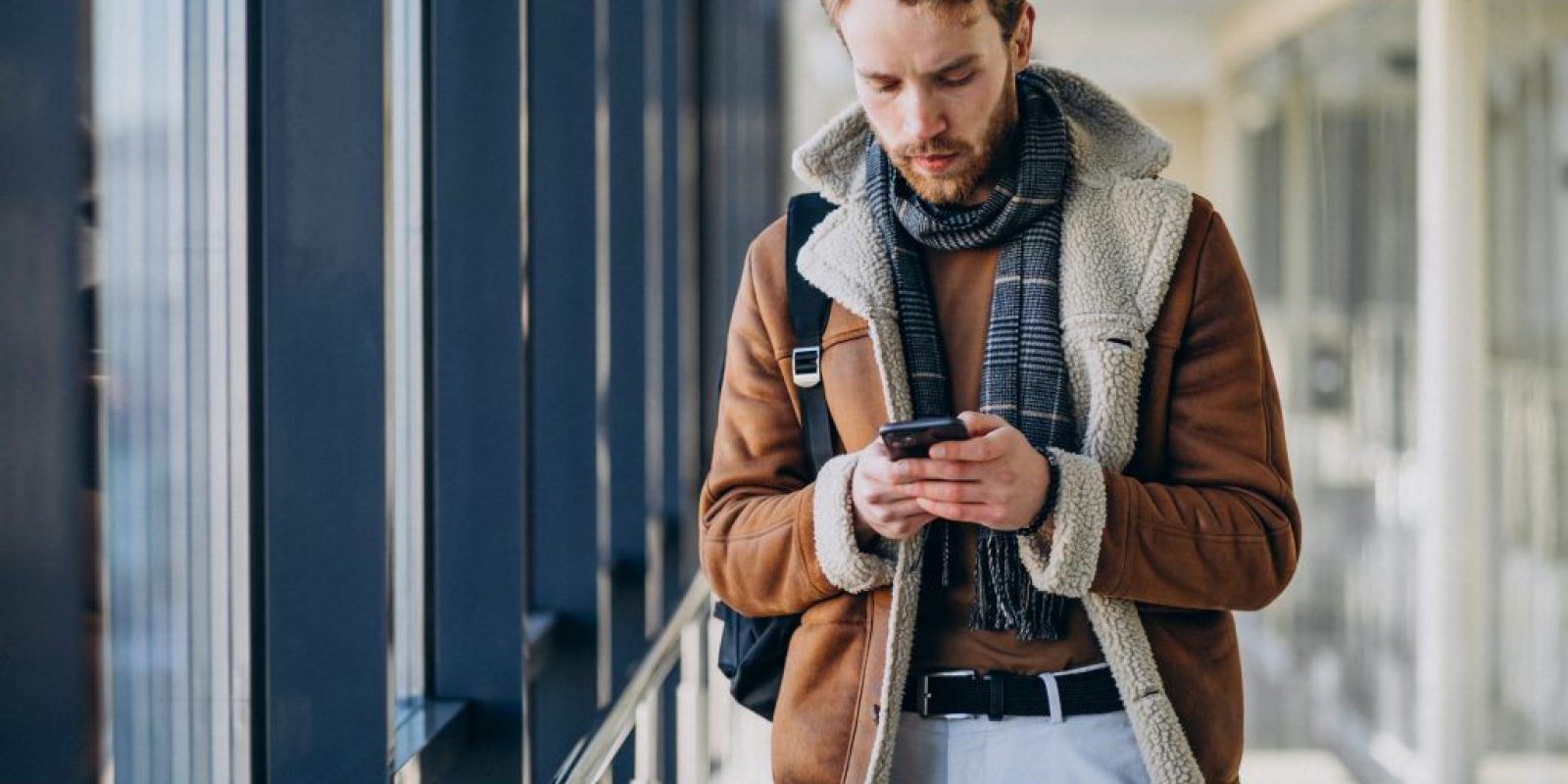 Young handsome man at airport talking on the phone