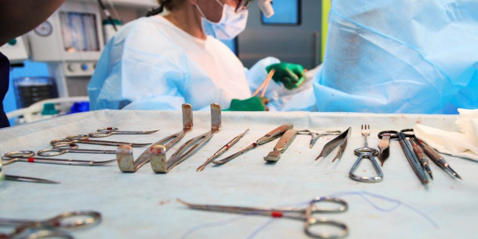 Surgical tools lying on table in surgical theatre. Steel medical instruments ready to be used. Surgery and emergency concept