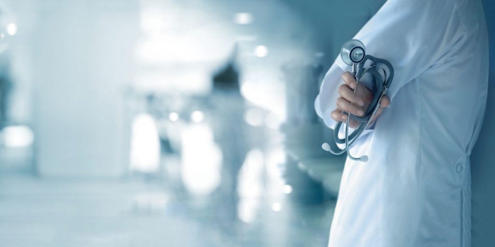 Doctor with stethoscope in hand on hospital background, medical