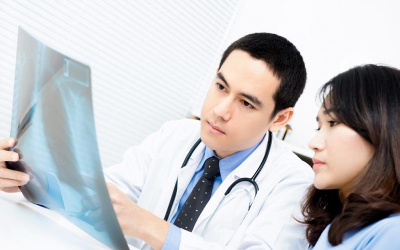 Doctor showing x-ray image to female patient