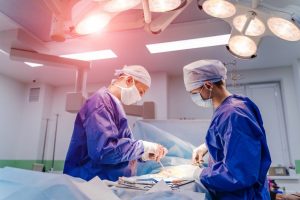 Group of surgeons in operating room with surgery equipment. Modern medical background. In surgery.