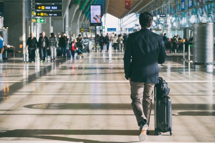 Close up of businessman carrying suitcase while walking through